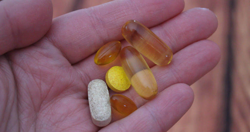 šaka u kojoj su četiri žute i jedna bela pilula